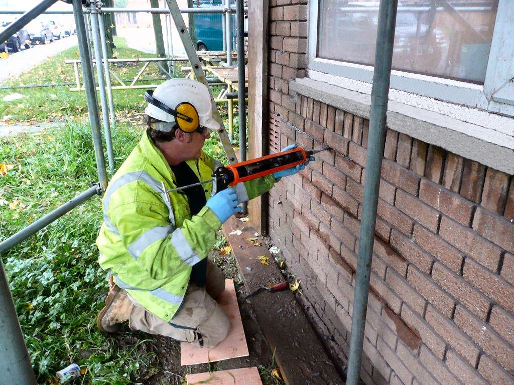 Protectahome Technician Inserting Grout for Helibar Installation