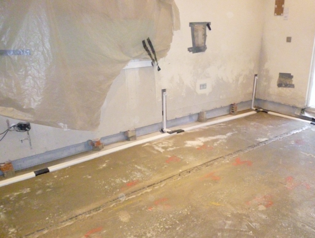 The basedrain has been cut and partially installed within the concrete floor. 